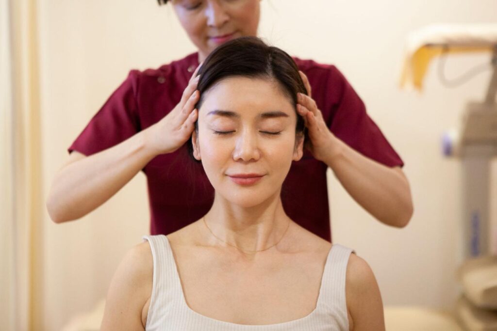 Therapist performing a Japanese scalp massage to relieve tension